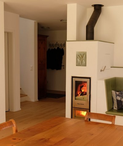 Der wasserführende Kaminofen sorgt als Holzheizung im Wohnbereich nicht nur für ein angenehmes Ambiente, sondern heizt auch den Speicher auf.