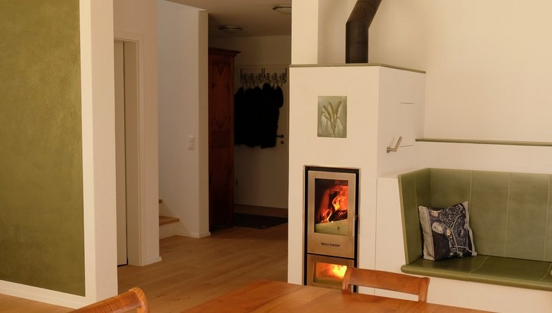 Der wasserführende Kaminofen sorgt als Holzheizung im Wohnbereich nicht nur für ein angenehmes Ambiente, sondern heizt auch den Speicher auf.