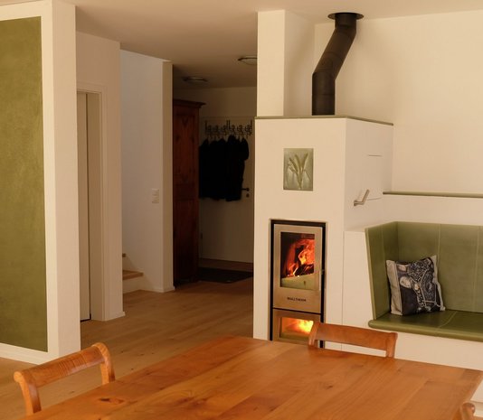 Der wasserführende Kaminofen sorgt als Holzheizung im Wohnbereich nicht nur für ein angenehmes Ambiente, sondern heizt auch den Speicher auf.