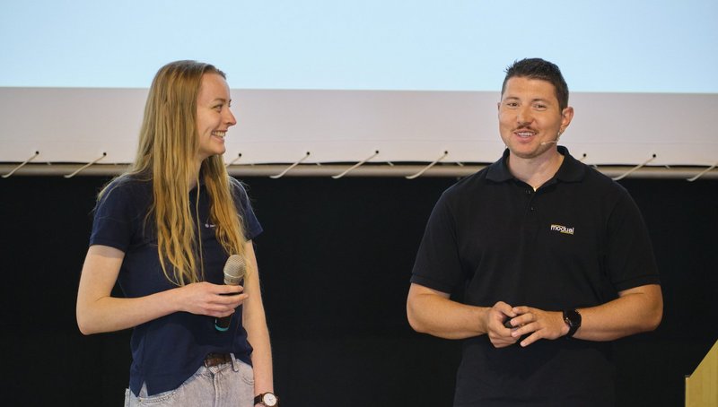Zwei Personen auf Bühne lachen zusammen