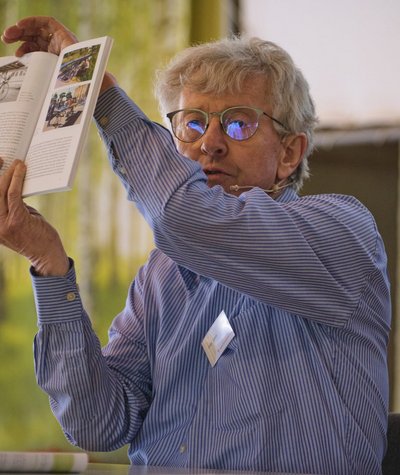 Mann zeigt Bilder aus einem Buch