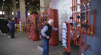 Produktionshalle mit Speicher-Ausstellungsmodellen und Personen