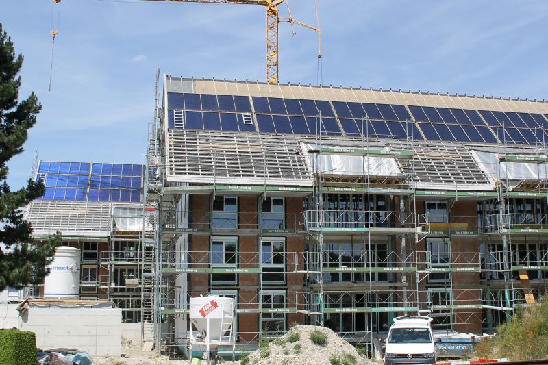 Solararchitektur bei Mehrfamilienäuser bedeutet grosse Fenster im Süden, Kollektoren auf dem Dach